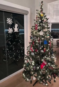 White Holiday Spray stencils sprayed next to a Christmas tree.